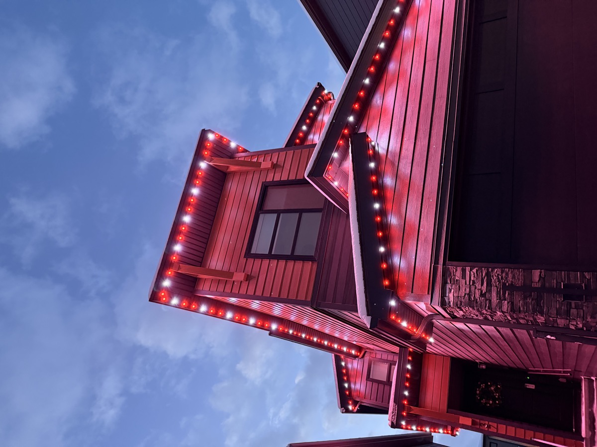 Permanent LED lights creating a dynamic party atmosphere on a Calgary home